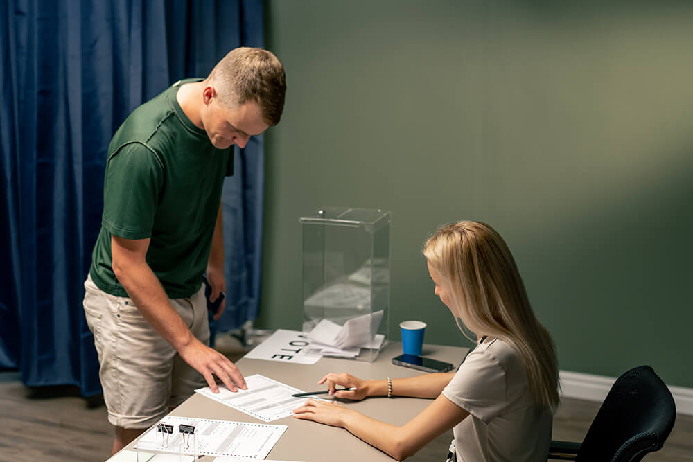 an image of a young woman helping a young man register to vote in Youngstown